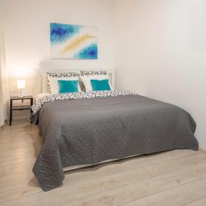 um quarto com uma cama grande e almofadas azuis em APARTMENT SAPICA em Solkan