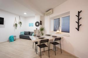 a living room with a table and chairs and a couch at APARTMENT SAPICA in Solkan