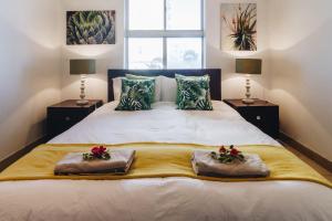 Un dormitorio con una cama grande con dos almohadas. en 104 Ipanema Beach, en Durban