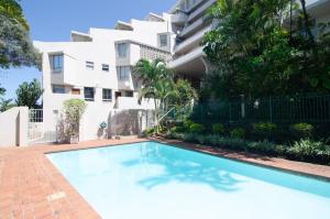 a swimming pool in front of a building at 104 Ipanema Beach in Durban