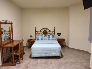 a bedroom with a bed and a dresser and a desk at Hotel Novo in Ponferrada