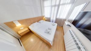 um pequeno quarto com uma cama e uma janela em Batumi Studio 1 em Batumi