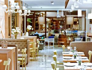 a restaurant with tables and chairs and a cafeteria at Hotel Ambassador in Pesaro