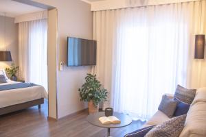 a hotel room with a couch and a tv at Hotel Osam - Adults Only in Supetar
