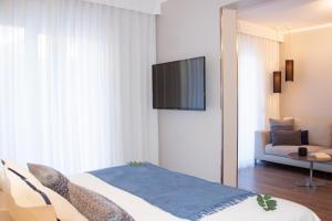 a bedroom with a bed and a television on a wall at Hotel Osam - Adults Only in Supetar
