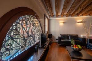 ein Wohnzimmer mit einem Sofa und einem Fenster in der Unterkunft Ve.N.I.Ce Cera San Moisè in Venedig