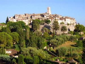 a town on a hill with trees and houses at Appartement Alpes Maritimes in Saint-Paul-de-Vence