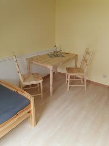 uma mesa de madeira e duas cadeiras num quarto em Hornbrooker Hostel em Dersau