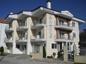 卡斯托里亞的住宿－Kyknos De Luxe Suites & Rooms，一座白色的大建筑,上面有标志