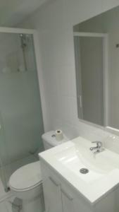 y baño con lavabo, aseo y espejo. en New Hortaleza Coliving, en Madrid