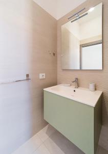 a bathroom with a sink and a mirror at Murphy Holiday Home - Residenza del centro in La Maddalena