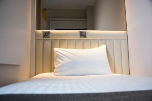 
a white bed with white sheets and pillows at Point A Hotel London Westminster in London

