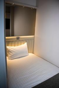 
a white bed with white sheets and pillows at Point A Hotel London Westminster in London
