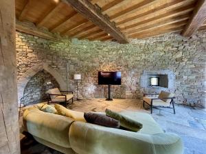 a living room with a couch in a stone wall at Le Château de Mirwart in Mirwart
