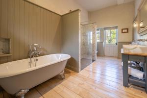 baño grande con bañera y lavamanos en Stunning luxury cottage in historic country estate - Belchamp Hall Stables, en Belchamp Otten