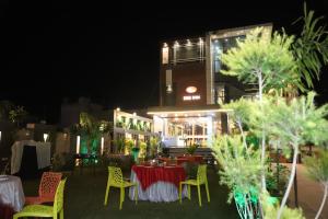 un ristorante con tavoli e sedie di fronte a un edificio di SRG INN HOTEL a Bharatpur