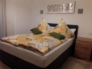 Un dormitorio con una cama con mantas y almohadas amarillas y verdes en Feriendomizil Berta Benzingen, en Winterlingen