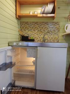 a kitchen with an open refrigerator and a sink at Jurmala`s Center Mini House in Jūrmala +11 photos