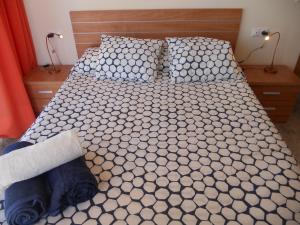 a bedroom with a bed with black and white sheets at Apartamento Azul Marino by Rental Olé in San Blas