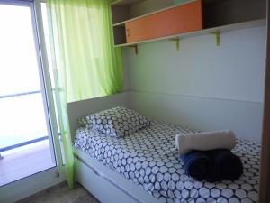 a small bed in a room with a window at Apartamento Azul Marino by Rental Olé in San Blas +10 photos