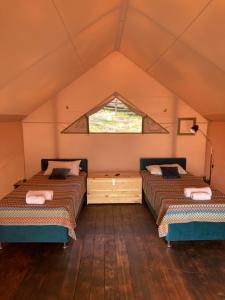 2 camas en una habitación con ventana en MIUSSERA SEA GLAMPING, en Gudauta