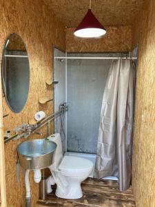 a bathroom with a sink and a toilet and a mirror at MIUSSERA SEA GLAMPING in Gudauta