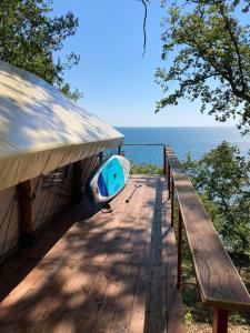 a house with a boat on a deck overlooking the water at MIUSSERA SEA GLAMPING in Gudauta