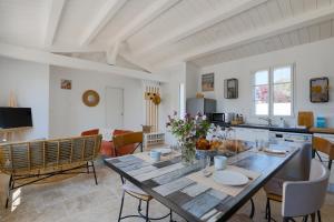 a kitchen and living room with a wooden table at À 550m de la plage, maison pour 4 in Saint-Martin-de-Ré