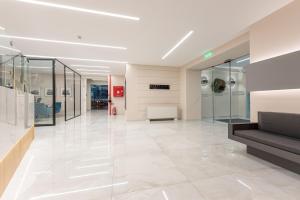 an empty lobby with glass walls and a staircase at Dionisos Hotel in Larisa