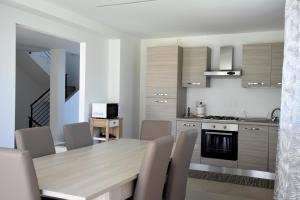 a kitchen and dining room with a wooden table and chairs at Villa al Mare in Bellaria-Igea Marina