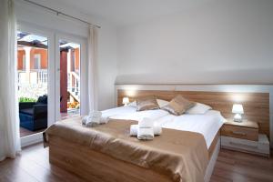 a bedroom with a large bed with towels on it at Mistral Apartments in Lopar