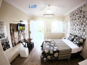Habitación de hotel con cama y TV en Pousada Miragem Do Mar Cabo Frio Praia Do Peró, en Cabo Frío
