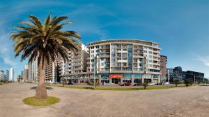 eine Palme vor einem hohen Gebäude in der Unterkunft Batumi Studio 1 in Batumi