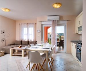 a kitchen and living room with a table and chairs at Mistral Apartments in Lopar