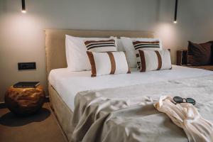 a bedroom with a large bed with white sheets and pillows at Cook's Club Ialysos Rhodes in Ialysos