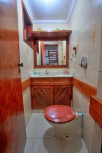 a bathroom with a toilet with a sink and a mirror at EXCELENTE CASA EM CABO FRIO - BRAGA in Cabo Frio