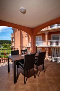 a patio with a table and chairs on a balcony at Mistral Apartments in Lopar