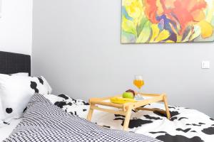 einen Tisch mit einem Glas Wein und Obst auf dem Bett in der Unterkunft C3 Modern Spartan Apartment in Sparta