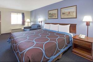 a hotel room with a large bed and a telephone at Super 8 by Wyndham Suwanee in Suwanee