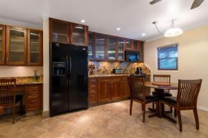 a kitchen with wooden cabinets and a wooden table at Days Inn by Wyndham Maui Oceanfront in Wailea