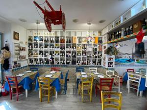 un ristorante con tavoli e sedie in una stanza di mondello sea view beach apartment a Palermo