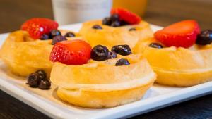 three pastries with strawberries and blueberries on a plate at Best Western InnSuites Tucson Foothills Hotel & Suites in Tucson