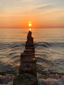 a stone pillar in the ocean with a sunset at "Ostsee Ankerplatz" in Markgrafenheide
