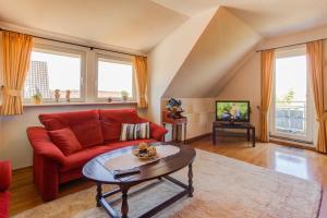 a living room with a red couch and a table at Haus Am See in Baabe