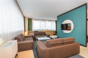 a living room with couches and a flat screen tv at Mirage Hotel in Kazan