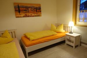 una camera con 2 letti singoli e cuscini gialli di Bayerwaldhäusl ad Arrach