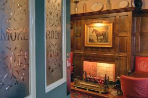 una sala de estar con chimenea y una foto de un caballo en Best Western Bell in Driffield, en Great Driffield