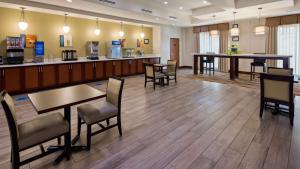 a waiting room at a hospital with tables and chairs at Best Western Plus Spring Inn & Suites in Spring