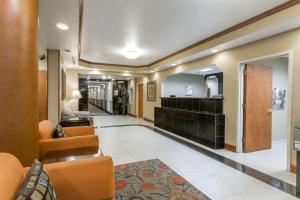 フォートピアースにあるDays Inn & Suites by Wyndham Fort Pierce I-95の椅子と鏡のあるホテルの廊下