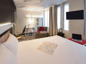 パリにあるイビス パリ ガール ドゥ レスト ディズィエムのベッドルーム1室(ベッド1台付)、リビングルームが備わります。